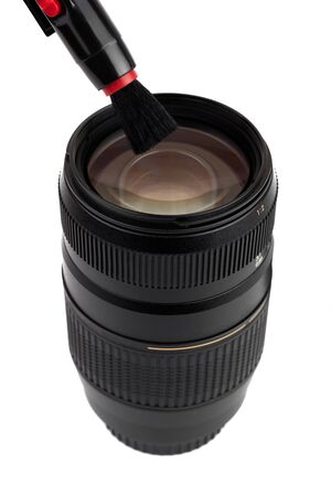 Photo lens and cleaning brush for optics isolated on white background. Lens pen with brush and travel zoom optics.の写真素材