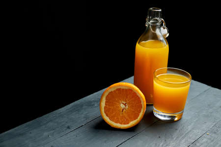 Glass of orange juice on wooden table with fresh sliced fruits of orange. Top view.の写真素材