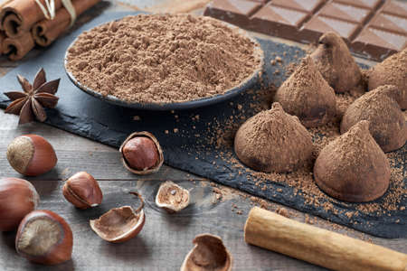 Different types of chocolate, cocoa powder, hazelnuts and other spices. Ingredients for making homemade truffles.の写真素材