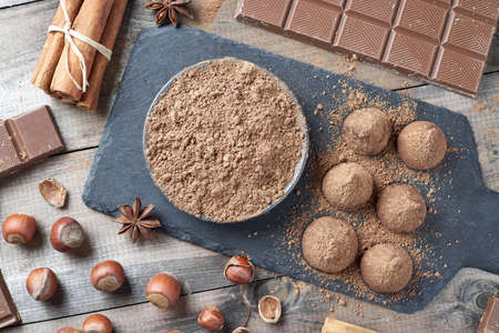 Different types of chocolate, cocoa powder, hazelnuts and other spices. Ingredients for making homemade truffles.の写真素材