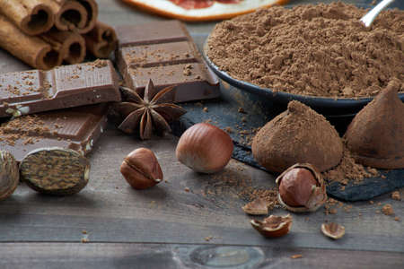 Different types of chocolate, cocoa powder, hazelnuts and other spices. Ingredients for making homemade truffles.の写真素材