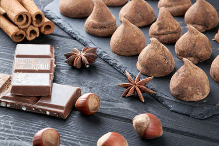 Homemade chocolate truffles and assorted chocolate with nuts and other spices on rustic old kitchen table.の写真素材