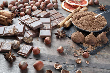Different types of chocolate, cocoa powder, hazelnuts and other spices. Ingredients for making homemade truffles.の写真素材