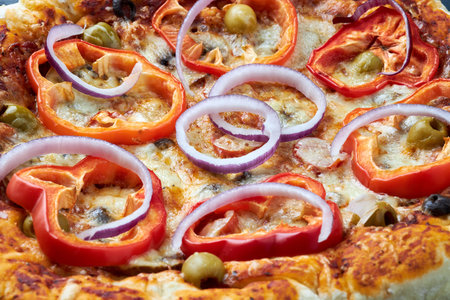 Tasty homemade pizza with tomato sauce and mozzarella cheese, decorated with red bell peppers, olives and purple onions. Close-up.の写真素材