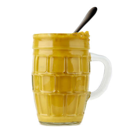 open glass jar with mustard stylized as a mug isolated on white backgroundの写真素材