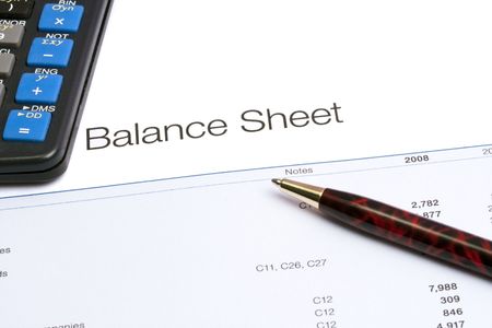 Closeup of a financial report, a pen and a calculator.の写真素材
