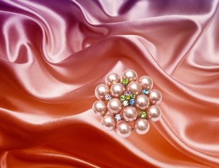 Beautiful brooch isolated on silk backgroundの写真素材