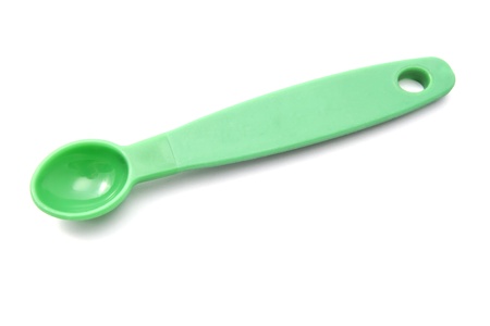 Green measuring spoon closeup on white background の写真素材