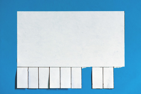 Tears tabs on the wall. Blank white paper announcement with tear off tabs.の写真素材