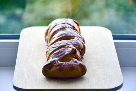 Homemade apple pie on a cutting wooden board, on a windowsill. Homemade baking.の写真素材