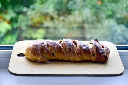 Homemade apple pie on a cutting wooden board, on a windowsill. Homemade baking.の写真素材