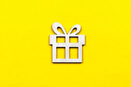 Decorative gift box made of plywood on a yellow background. Christmas and event decorative elementsの写真素材
