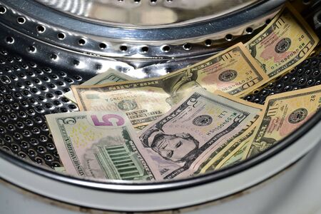 Banknotes in the washing machine, money laundering. Process of making illegally-gained proceeds (dirty money) appear legal (clean)の写真素材