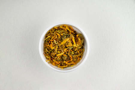 Pot marigold, common marigold, ruddles or marigold medicinal plant used in herbal medicine. Herb in a white cup.の写真素材