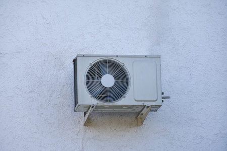 Wall mounted air conditioning unit on the wall of the house