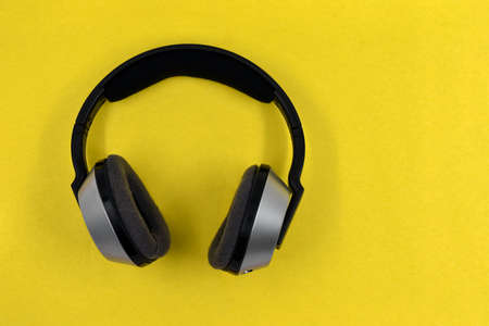Wireless headphones on yellow background, photo directly aboveの写真素材