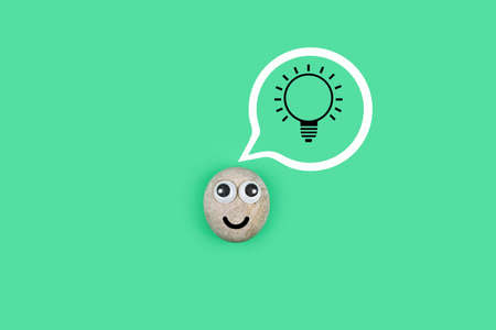 Character from a pebble with a happy face and a burning light bulb in his mind. Ð¡haracter from the pebble found a solutionの写真素材