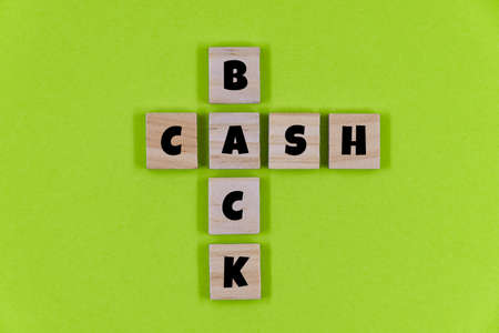 Wooden cube block with the word Cashback on green paper backgroundの写真素材