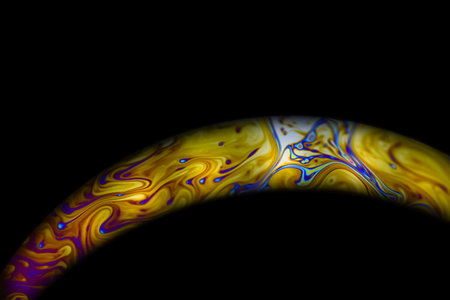 Closeup soap bubble like an planet on dark background. Abstract multicolor psychedelic planet in...