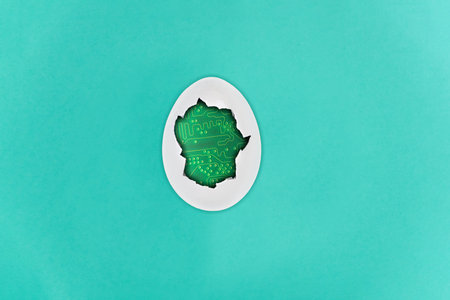 Broken, cracked white egg with electronic circuit inside, isolated on a blue paper background
