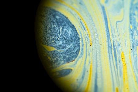 Multicolor psychedelic abstract round planet in universe. Closeup soap bubble like an alien planet on dark backgroundの写真素材