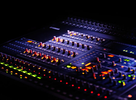 mixer or mixing concole in the dark, with blurry lights and controllersの写真素材