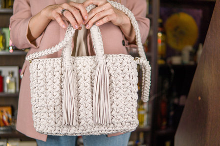 Elegant handbag in the hands of a young woman.の写真素材