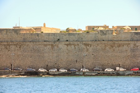 Line of cars parking in port Grand Harbor, Valletta in sunny dayの写真素材