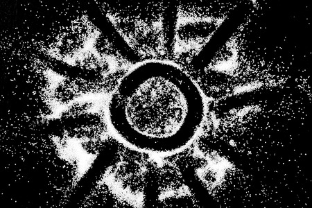 White salt powder sun symbol circle round cloud on black background. Concept with place for text. Copy space.の写真素材