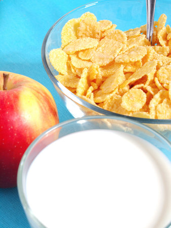 Apple, milk, and corn flakes close up