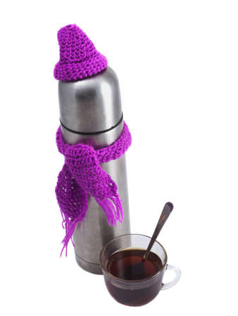 Thermos in a scarf and hat with a cup on a white backgroundの写真素材
