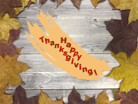 Vintage background on wooden boards and autumn maple leaves with Thanksgiving greetings.の写真素材