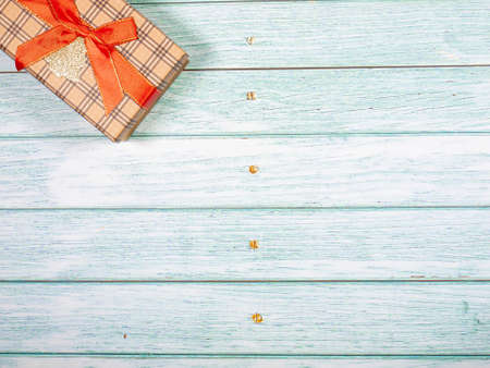 Gift box tied with a ribbon on a vintage background of boards. The concept of a holiday card.の写真素材