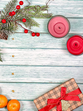 Christmas festive background of pine branches, ornaments and gifts with tangerines on vintage...