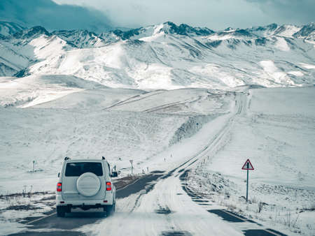 The SUV is moving along a winter road in the mountains. The concept of auto travel.の写真素材