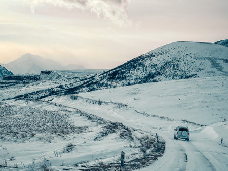 The SUV is moving along a winter road in the mountains. The concept of auto travel.の写真素材