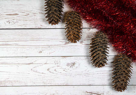 Fir cones and red garlands in the right corner on a wooden background. background for recording.の写真素材