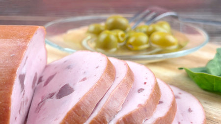 Still life of sliced sausage and olives close-up on a wooden table. home gastronomy.の写真素材