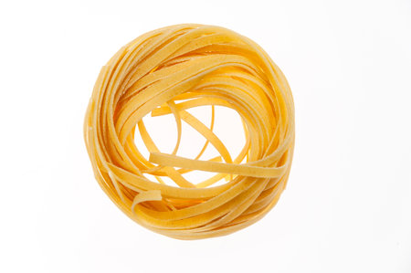 Nests of raw pasta on a white background. The concept of Italian cuisine.の写真素材