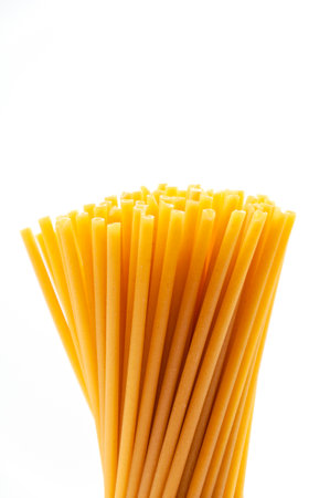 A bunch of raw pasta in the form of tubes on a white background. The concept of healthy and healthy food.の写真素材