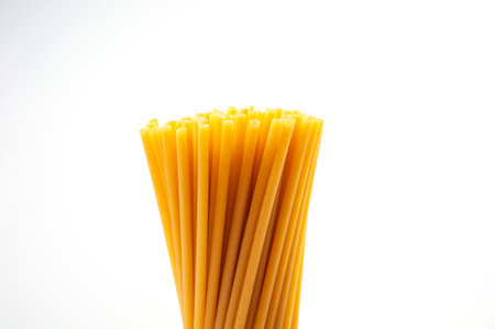 A bunch of raw pasta in the form of tubes on a white background. The concept of healthy and healthy food.の写真素材