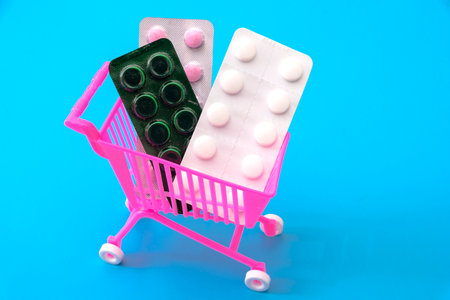 A supermarket cart with pills on a blue background.の写真素材