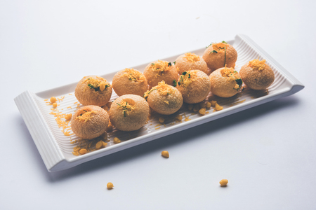 Stuffed Sev Puri is a popular Indian roadside chat item, served in a white plate. Top view, selective focusの写真素材