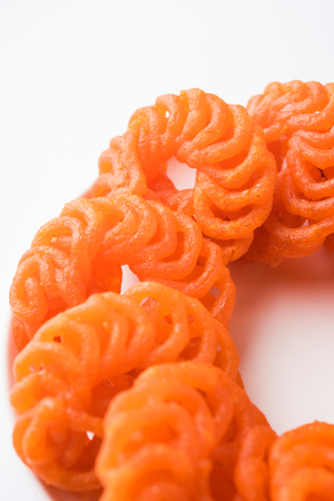Indian sweet Imarti or Jalebi served in white ceramic plate over white backgroundの写真素材