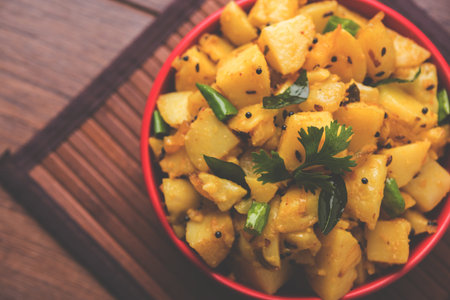 Chatpate Masala Aloo Sabzi fry OR Bombay potatoes served in a bowl, selective focusの写真素材