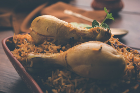 Indian Chicken Biryani served in a terracotta bowl with yogurt over white background. selective focusの写真素材