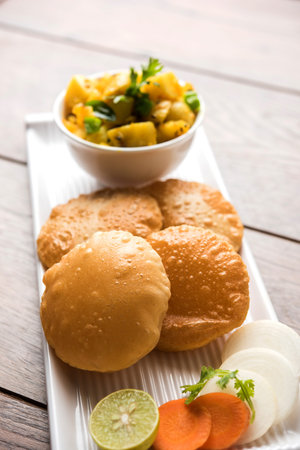 Chatpate Masala Aloo Sabzi fry OR Bombay potatoes served with fried puri or Indian bread made up of...