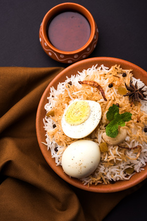 Egg Biryani - Basmati rice cooked with masala roasted eggs and spices and served with yogurt, selective focusの写真素材