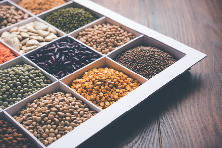 Indian Beans,Pulses,Lentils,Rice and Wheat grain in a white wooden box with cells, selective focus.の写真素材