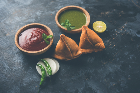 Samosa snack served with tomato ketchup and mint chutneyの写真素材